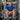 Man in a blue shirt sitting among industrial brewing equipment