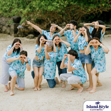 Peñano Family Holiday | Custom Christmas Hawaiian Shirts worn by a family posing playfully on a beach, showcasing matching tropical-themed outfits.