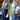 Two individuals in uniform with green and yellow neckerchiefs standing outdoors.