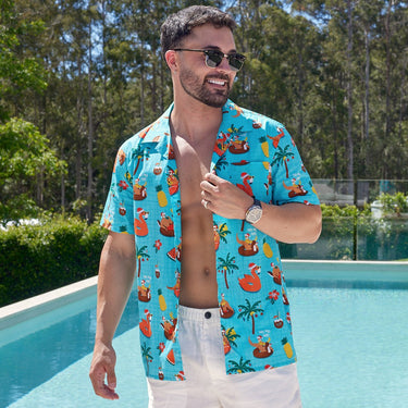 Men's Christmas Pool Party shirt with tropical Santa and cocktail print, styled for summer holidays by the pool or beach.