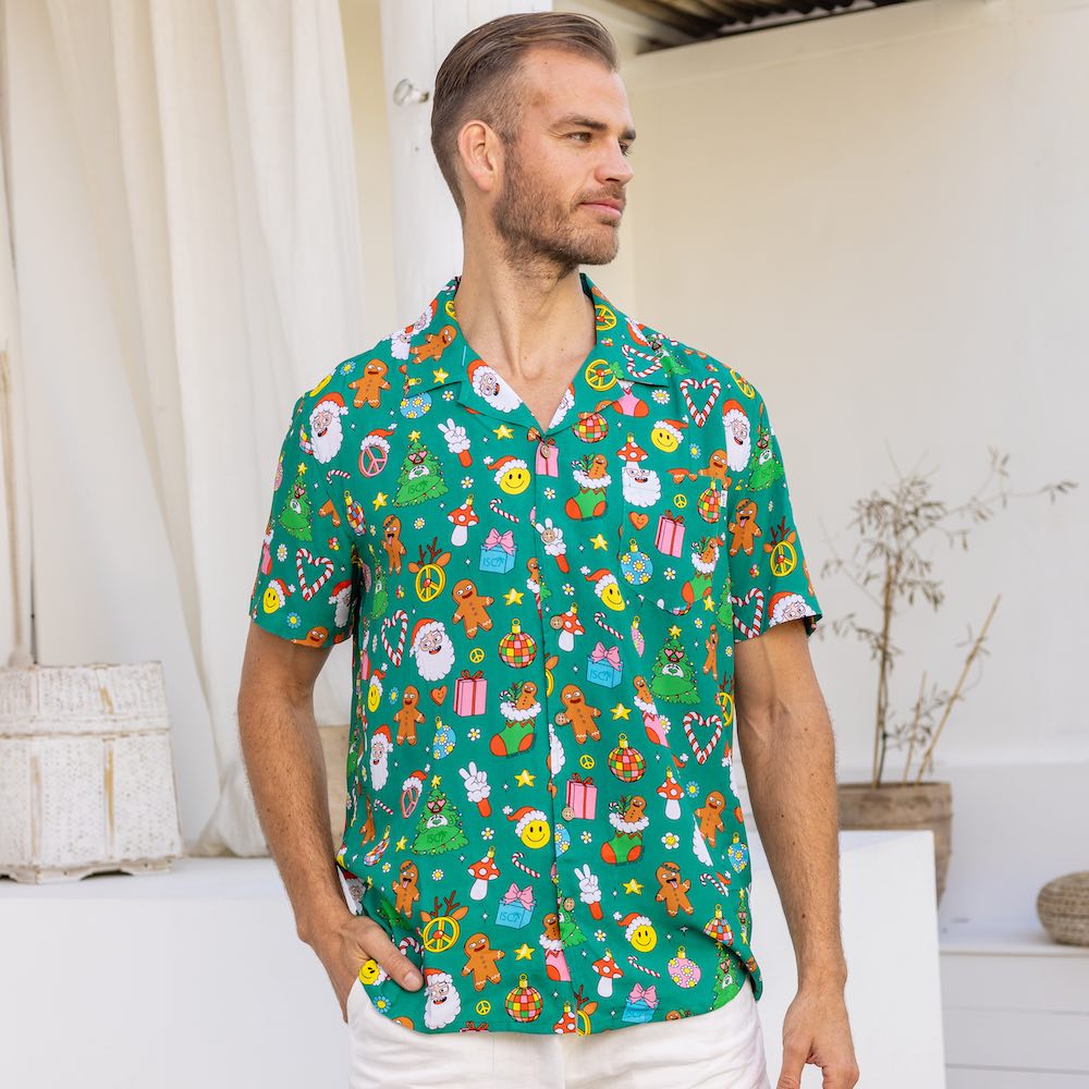 Stay festive all season long in the Holidaze shirt! Crafted from a soft rayon material, it merrily blends colourful, retro Christmas elements – from gingerbread to Santa to candy canes – all atop a festive green base. Make the holidays bright with it!