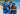 Three people in matching blue outfits standing on a beach with ocean in the background