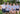 Group of people wearing matching blue and white patterned shirts outdoors.