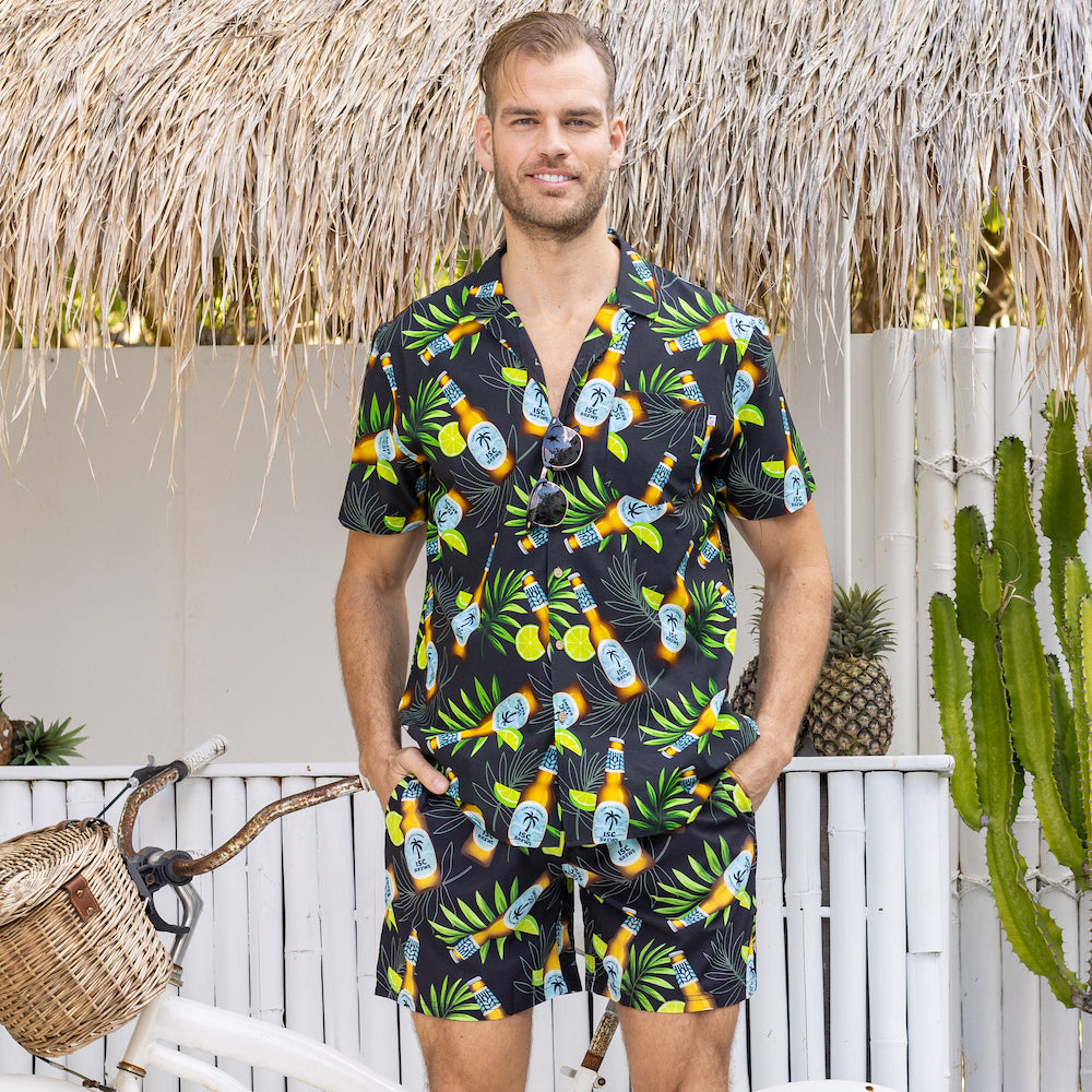 Ready to turn your next vacation into a "Happy Hour"? Show off your tropical style with this shirt and shorts set - featuring an in-house design with beer bottles, limes and leaves on a black base. So cheers to you, and to always having the coolest look!  This Shirt is breathable and lightweight cotton rayon blend and the shorts are quick-drying and durable made from recycled plastic bottles! 