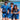 Three people in matching blue outfits with sunglasses and drinks by a beach.