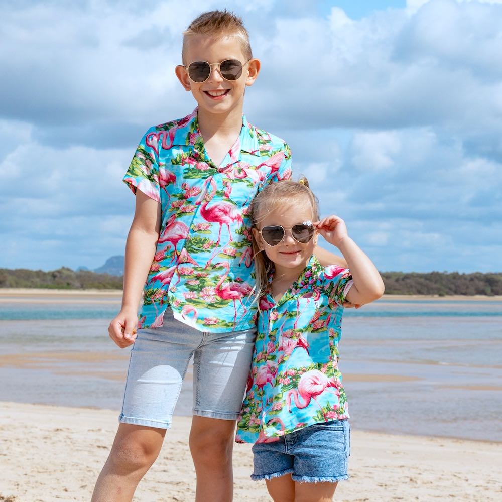 Watch your coolest kiddo come alive in our Turquoise Flamingo Hawaiian Shirt! This features a vibrant blue base with pink flamingos to keep 'em smiling in style! Perfect for boys & girls alike, it's the perfect summer look for hangin' at the beach, cruising around town, or just plain ol' chillin.  Matching family items? We got the whole gang covered! View the Turquoise Flamingo collection