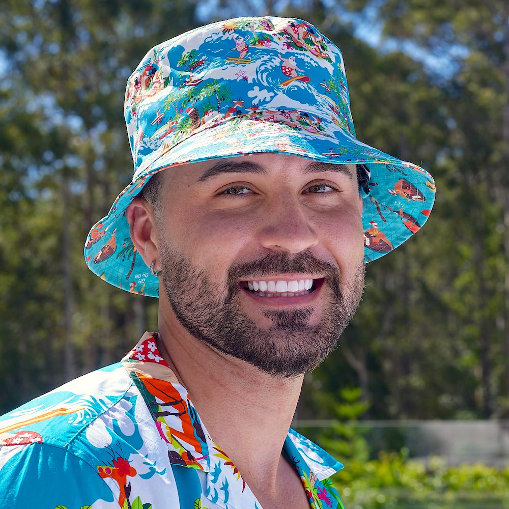 Bringing you the perfect way to polish off your show-stopping Christmas 'fit. Get two for the price of one with our reversible bucket hats. One side is our Blue Surfing Santa and the other side will be Christmas Pool Party. It's made for the Aussie summer and great for keeping off the sun on Christmas Day. It also perfectly pairs with matching Xmas shirts and shorts.