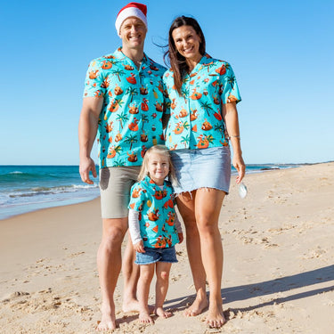a man, woman and child standing on a beach   