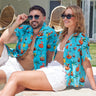 a man and a woman sitting on the ground wearing Christmas shirts