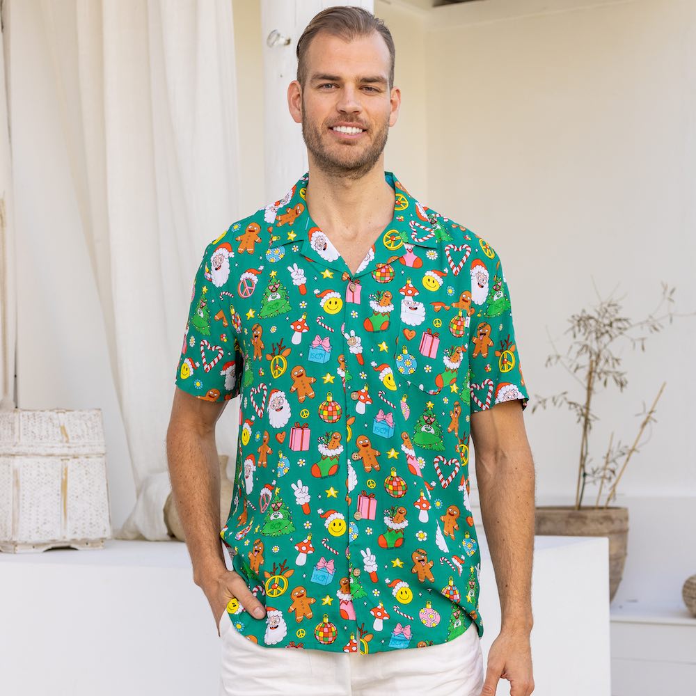 Stay festive all season long in the Holidaze shirt! Crafted from a soft rayon material, it merrily blends colourful, retro Christmas elements – from gingerbread to Santa to candy canes – all atop a festive green base. Make the holidays bright with it!