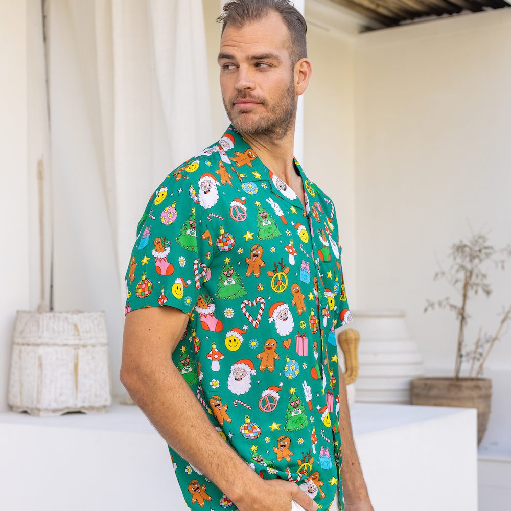 Stay festive all season long in the Holidaze shirt! Crafted from a soft rayon material, it merrily blends colourful, retro Christmas elements – from gingerbread to Santa to candy canes – all atop a festive green base. Make the holidays bright with it!
