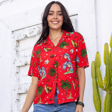 a woman standing next to a cactus wearing a red shirt