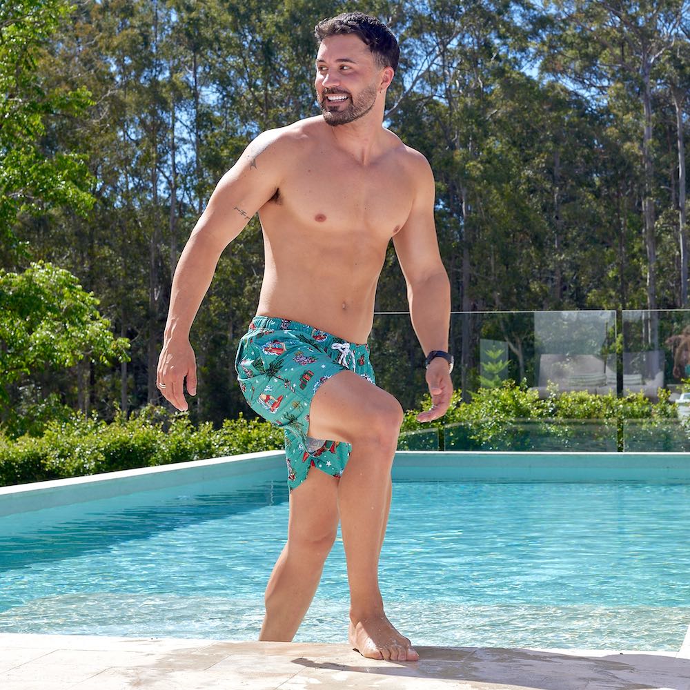 Slip on our Aussie Christmas Green - Festive Swim Shorts and take a dip in style! Made from recycled polyester, these fun-filled shorts feature Surfing Santa, Aussie flowers and animals, and candy canes galore – perfect for a festive beach day! Soak up the sun in your eco-friendly, seriously stoked shorts!