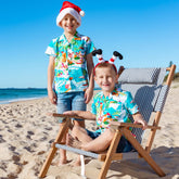 Get ready to hang ten with Blue Surfing Santa! This stylish 100% Cotton Hawaiian Christmas shirt is the perfect way to kick off the holiday season with fun and festive flair. Your little kids will be shredding waves with Santa Claus and his trusty reindeers in no time! Let the holiday season start with a splash! 🌊