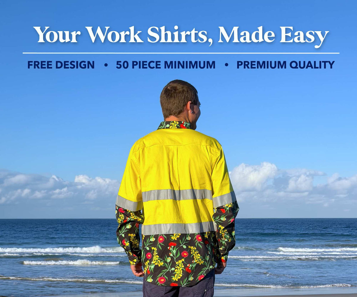 A man stands on a beach facing the ocean, wearing a bright yellow work shirt with reflective silver stripes and a green floral patterned collar and sleeves. Large text at the top reads 'Your Work Shirts, Made Easy' with smaller text 'FREE DESIGN • 50 PIECE MINIMUM • PREMIUM QUALITY'.