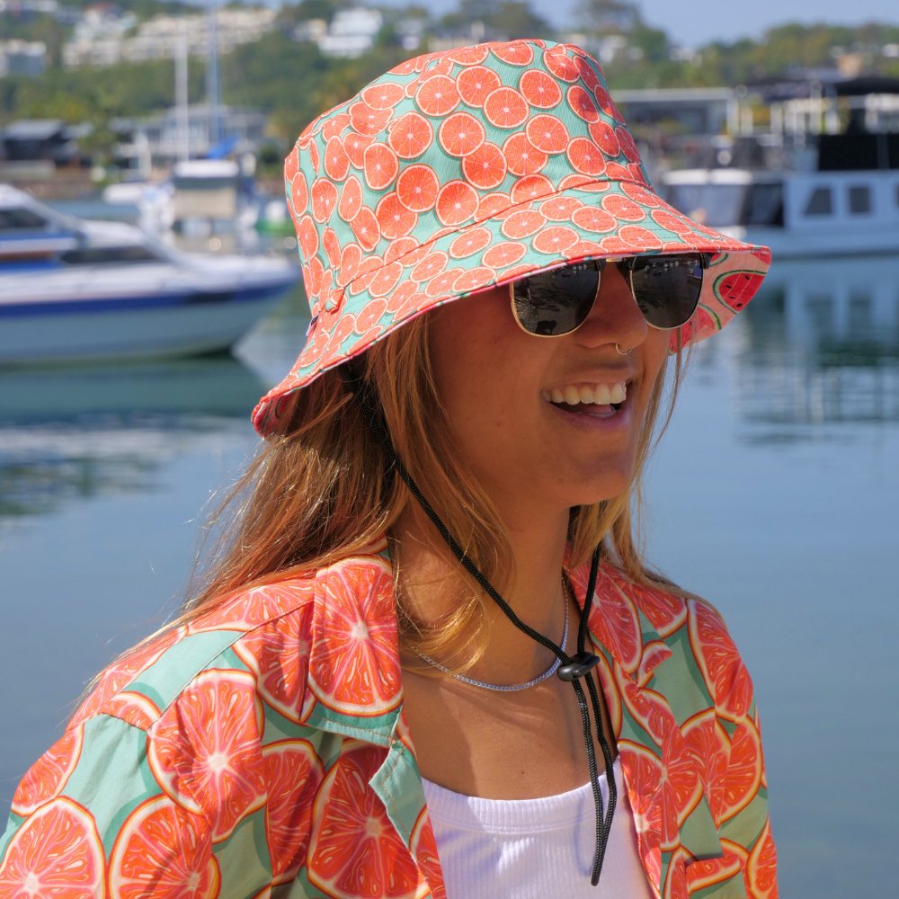 Bringing you the perfect way to top off your show-stopping Festival 'fit. Get two for the price of one with our reversible bucket hats. One side is our Groovy Grapefruit and the other side is our Shake Ya Melons. Pimm's o'clock is approaching; you pour, we've prepped the fruit. Level up the look with the Matching Mens or Unisex Shirts Groovy Grapefruit Reversible design - Shake Ya Melons on the flipside 100% Polyester Brim width - 6cm