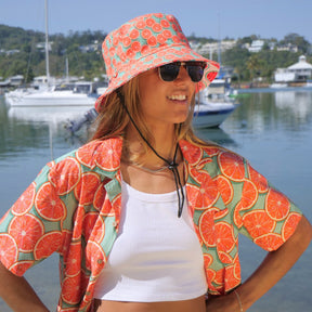 Bringing you the perfect way to top off your show-stopping Festival 'fit. Get two for the price of one with our reversible bucket hats. One side is our Groovy Grapefruit and the other side is our Shake Ya Melons. Pimm's o'clock is approaching; you pour, we've prepped the fruit. Level up the look with the Matching Mens or Unisex Shirts Groovy Grapefruit Reversible design - Shake Ya Melons on the flipside 100% Polyester Brim width - 6cm