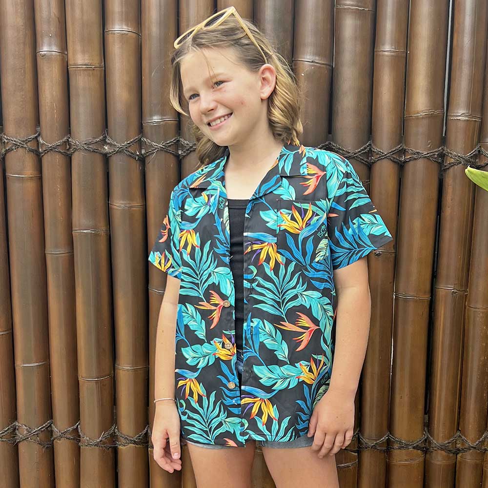 Make sure your kiddos look cool and trendy in our Jungle Fever Hawaiian Shirt! With its 100% cotton print of tropical lush leaves, they'll be ready to take on summer with style and comfort.  The perfect ensemble for a day of casual cruisin' with the whole family! Unisex design so everyone can have a matching look! 