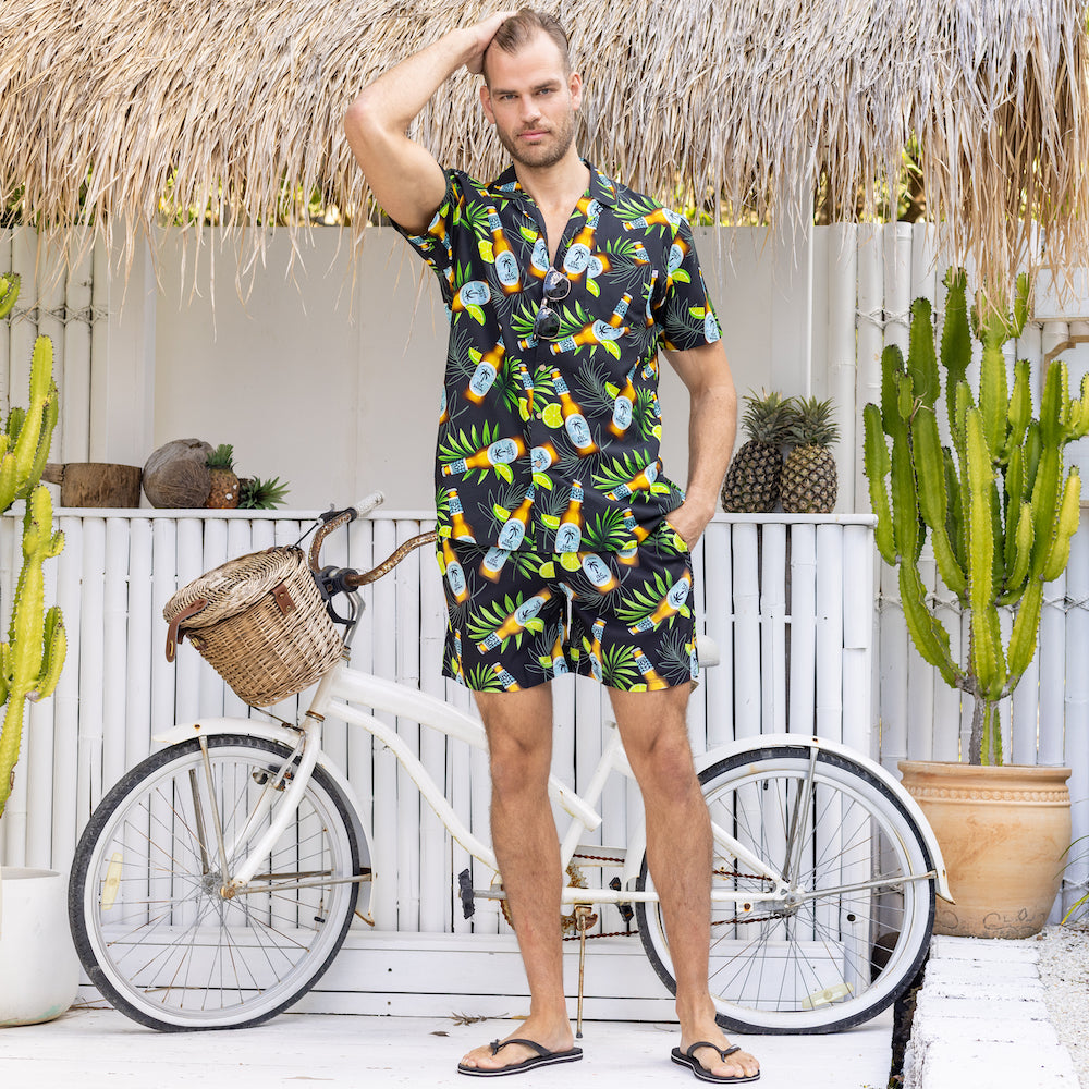 Ready to turn your next vacation into a "Happy Hour"? Show off your tropical style with this shirt and shorts set - featuring an in-house design with beer bottles, limes and leaves on a black base. So cheers to you, and to always having the coolest look!  This Shirt is breathable and lightweight cotton rayon blend and the shorts are quick-drying and durable made from recycled plastic bottles! 