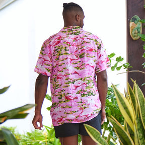 This classic men's Hawaiian shirt features vibrant pink flamingos printed on 100% rayon fabric. Complete with coconut buttons, it's perfect for a stylish yet comfortable island-style look. Steal the spotlight everywhere you go.  Go all out matching with the whole family! Shop the Pink Flamingo Collection. 