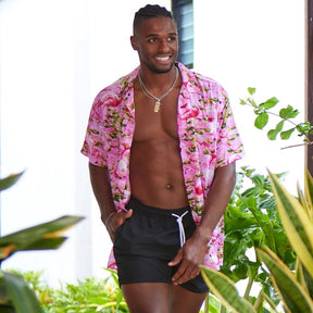 This classic men's Hawaiian shirt features vibrant pink flamingos printed on 100% rayon fabric. Complete with coconut buttons, it's perfect for a stylish yet comfortable island-style look. Steal the spotlight everywhere you go.  Go all out matching with the whole family! Shop the Pink Flamingo Collection. 