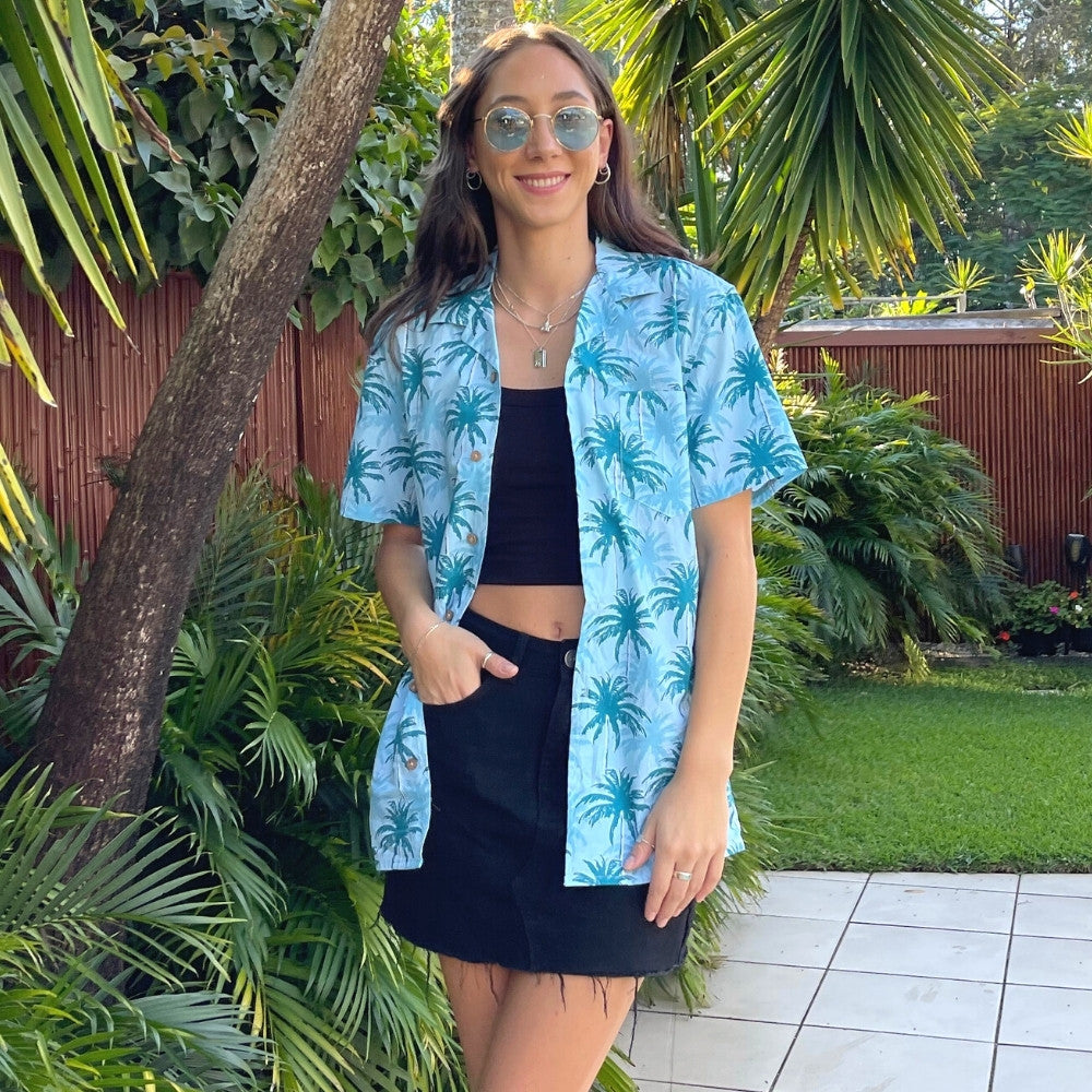 Let yourself feel the island vibes with this unique blue aloha shirt. The classic Hawaiian pattern with palm trees will have you feeling like a beachcomber even in corporate headquarters!  100% cotton ensures a comfortable fit for all day wear, whether you’re heading out on a cruise or to the office. It's truly a shirt "to-tally" worth getting your hands on!