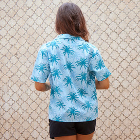 Sport your island look with this Island Blues Women's Hawaiian shirt. Perfect for a cruise or an aloha-inspired uniform, this 100% cotton shirt is that tropical paradise you've been dreaming of! With an eye-popping palm tree print in classic blues, it will have you ready for some sweet island vibes. Aloha!