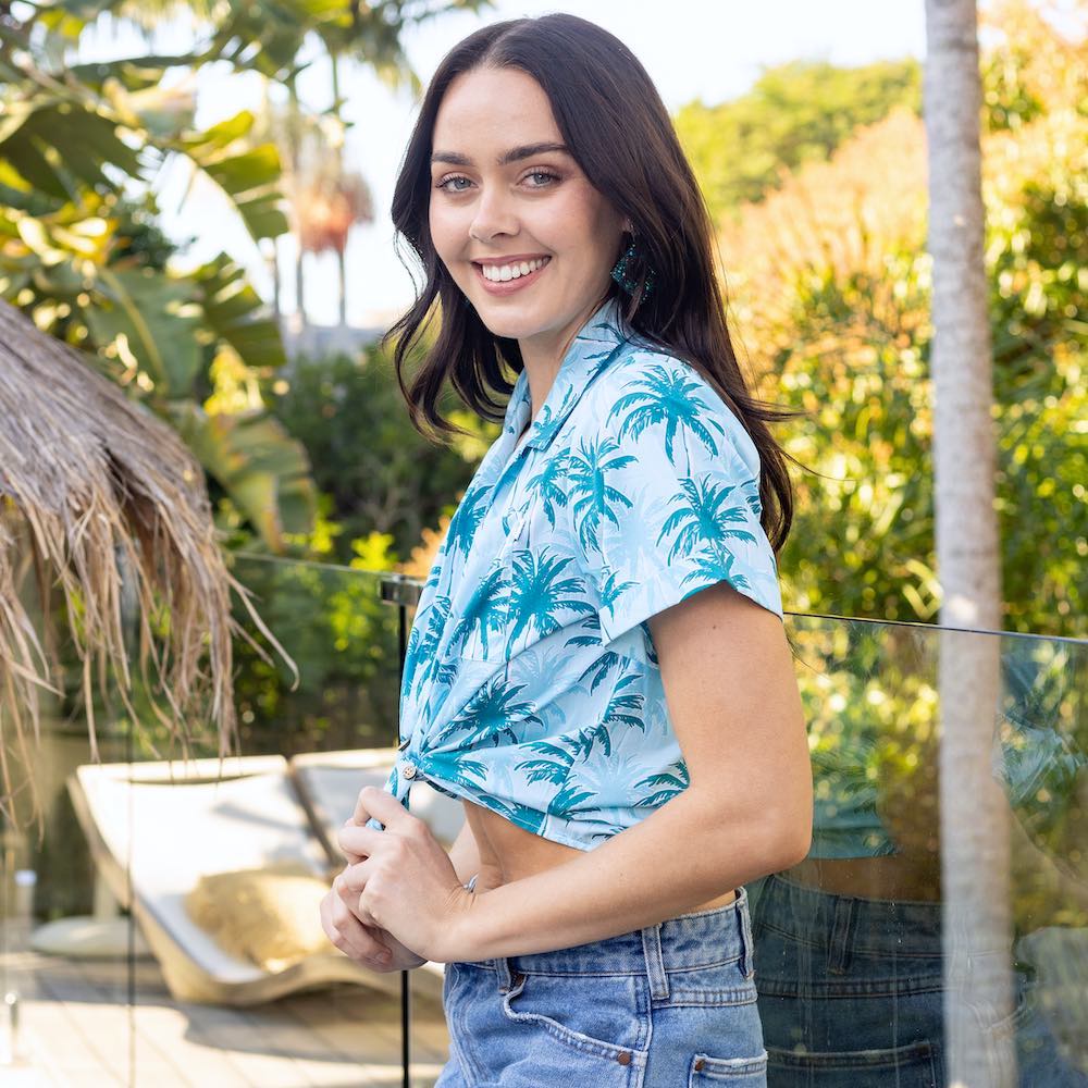 Our Island Blues crop shirt is essential for having a sunny Aussie summer! Made with 100% cotton, it features an allover print of palm trees in blue tones – perfect for a casual laidback look and great for uniforms. Enjoy the heat without sweating it!