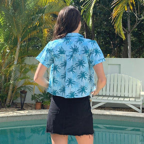 Our Island Blues crop shirt is essential for having a sunny Aussie summer! Made with 100% cotton, it features an allover print of palm trees in blue tones – perfect for a casual laidback look and great for uniforms. Enjoy the heat without sweating it!