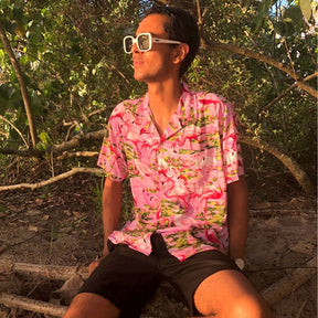 This classic men's Hawaiian shirt features vibrant pink flamingos printed on 100% rayon fabric. Complete with coconut buttons, it's perfect for a stylish yet comfortable island-style look. Steal the spotlight everywhere you go.
